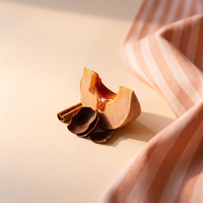 Ambiance d'automne : courge caramélisée, cannelle et cacao sur un linge rayé pêche